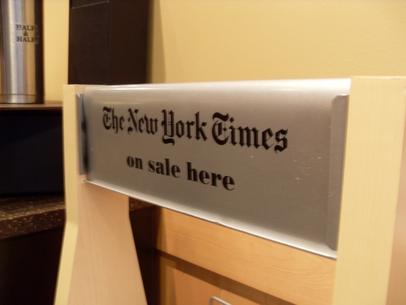 picture of a sign that says "NY TIMES ON SALE HERE"