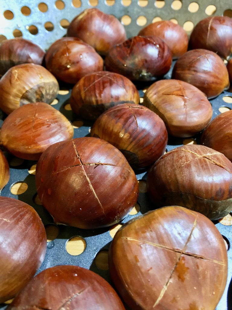 2-inch chestnuts, scored with an "x" on their rounded shell surfaces