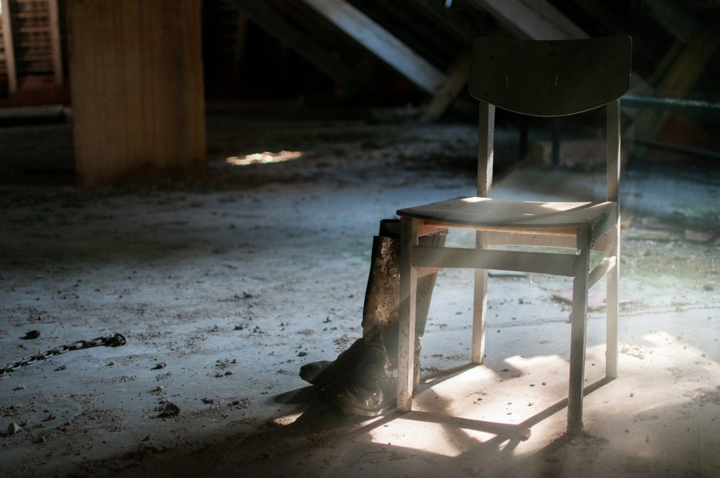 empty wooden chair against a background of abandoned room